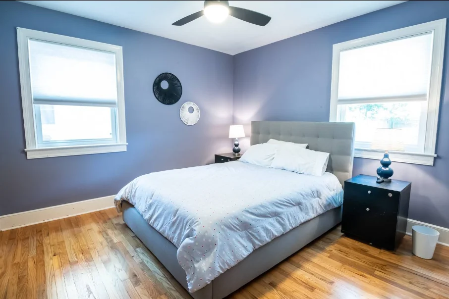 Neatly prepared vacation rental bedroom with lavender walls