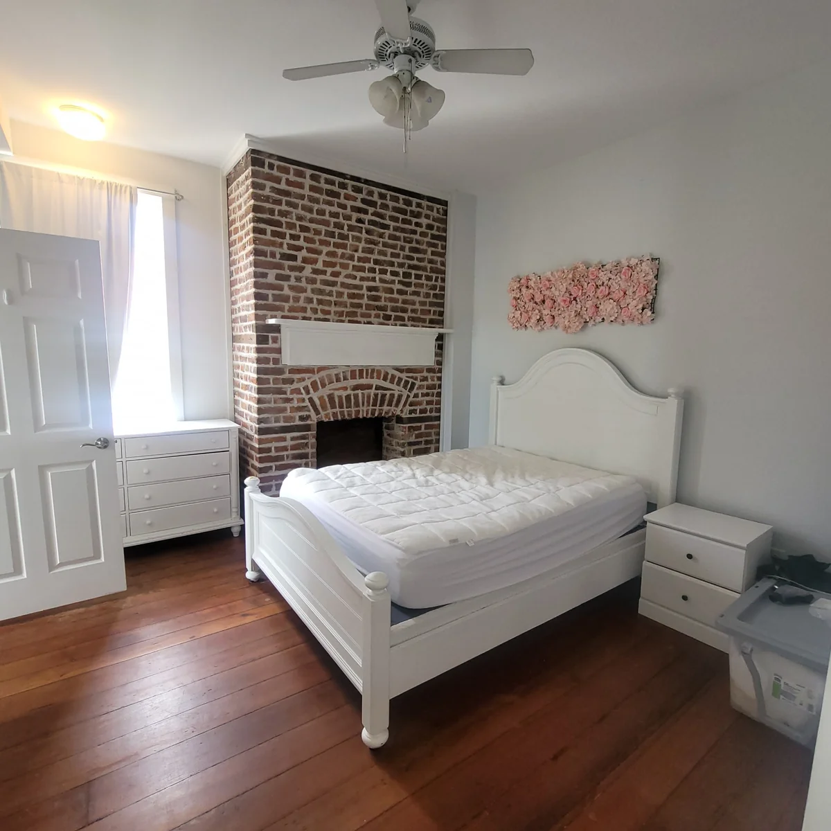 Clean bedroom with exposed brick fireplace